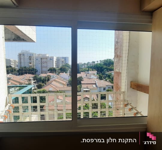 חלון אלומיניום עם מסגרת לבנה ומעקה חיצוני